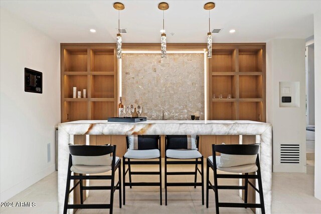 kitchen featuring white cabinetry, light stone counters, pendant lighting, ceiling fan, and a spacious island