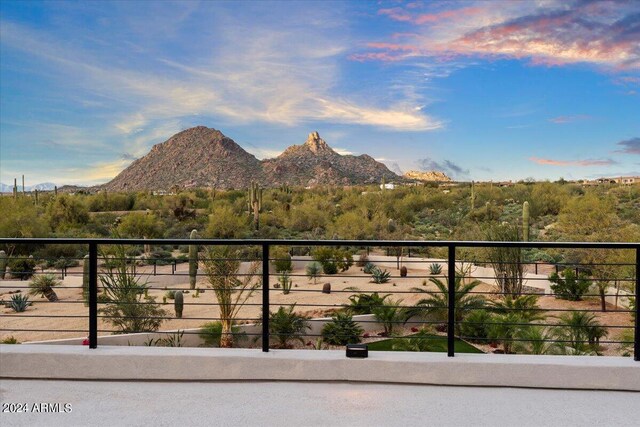 pool at dusk featuring a mountain view, an in ground hot tub, and a patio area