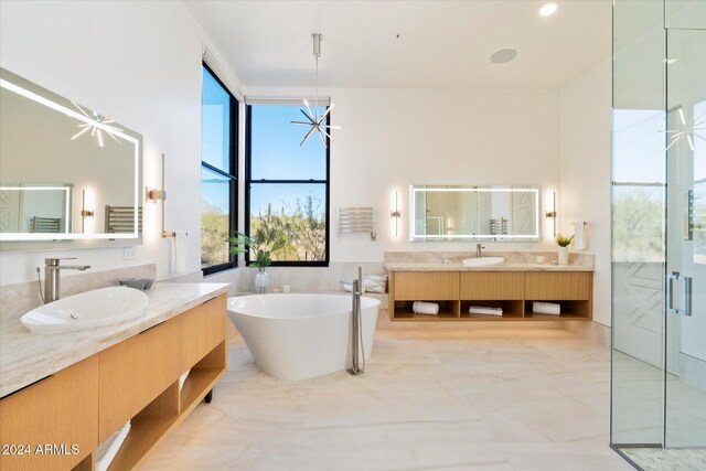 bathroom featuring vanity, a bathing tub, and a chandelier