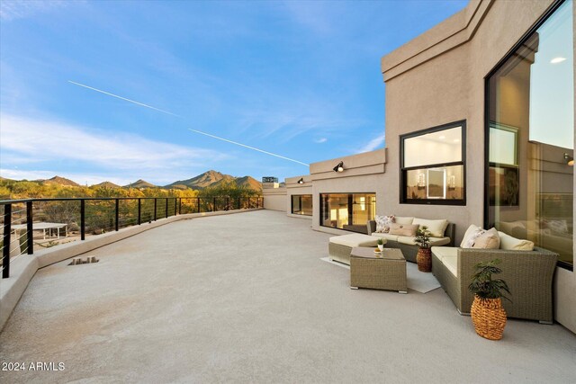 view of patio with ceiling fan and an outdoor living space with a fire pit