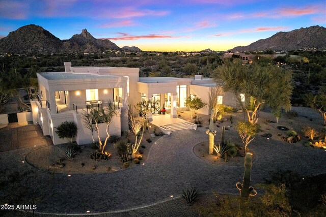 rear view of property featuring a mountain view, a swimming pool with hot tub, a patio, an outdoor hangout area, and a balcony