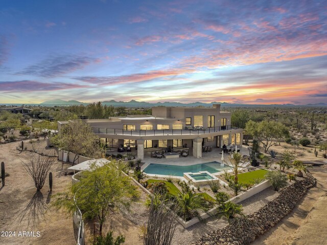 pool at dusk with a patio area