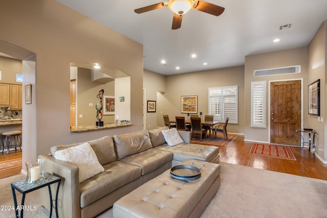 living room with wood-type flooring and ceiling fan