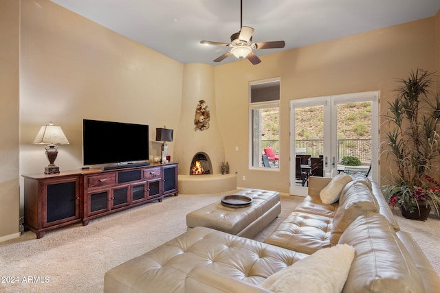 living room featuring light colored carpet, a large fireplace, and ceiling fan