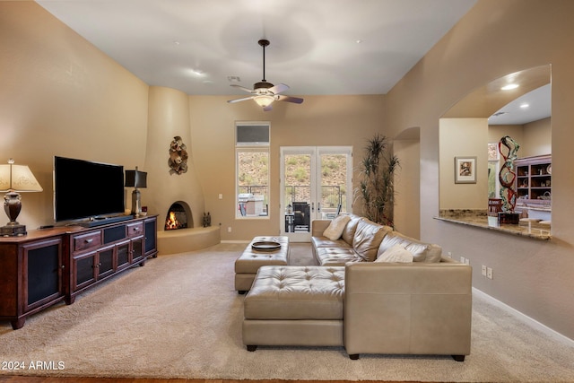 carpeted living room featuring a fireplace and ceiling fan