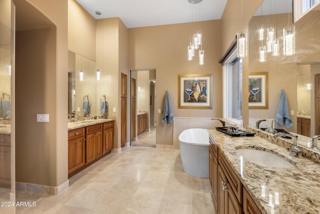 bathroom with vanity, a high ceiling, tile patterned flooring, and a bathing tub