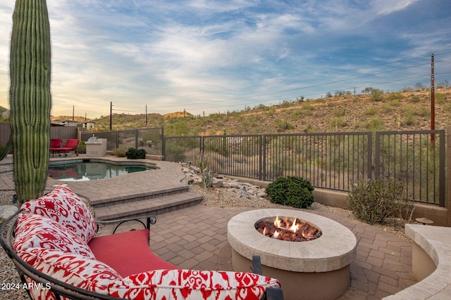 view of patio / terrace featuring a fenced in pool and a fire pit