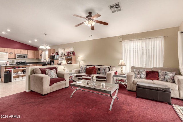 carpeted living room featuring ceiling fan with notable chandelier, vaulted ceiling, and sink