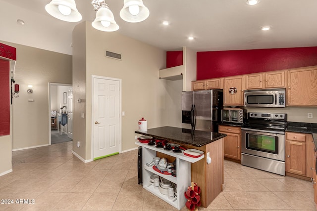 kitchen featuring appliances with stainless steel finishes, high vaulted ceiling, a notable chandelier, a center island, and light tile patterned flooring