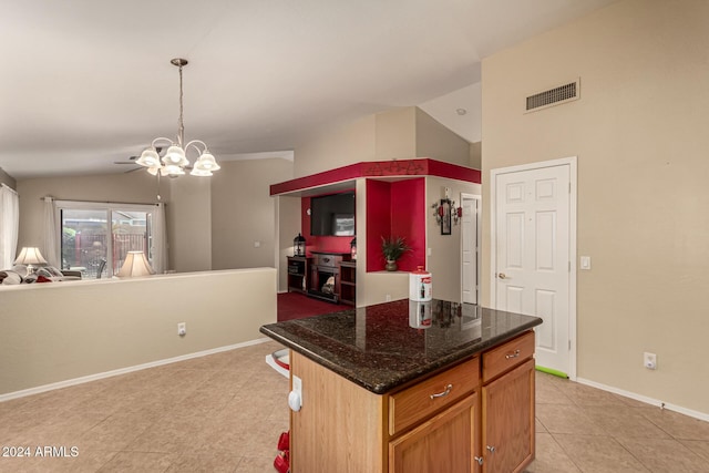 kitchen featuring a kitchen island, an inviting chandelier, light tile patterned flooring, and vaulted ceiling