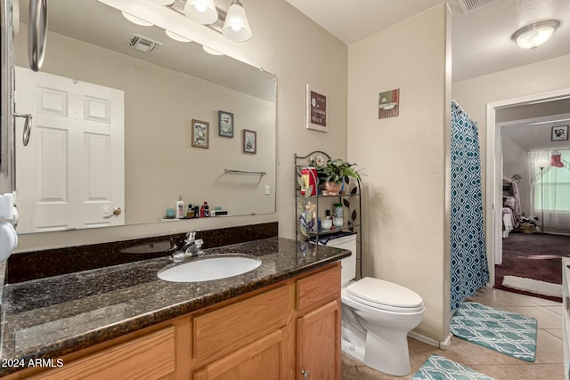 bathroom featuring toilet, vanity, and tile patterned floors