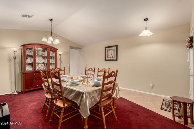 dining room featuring tile patterned flooring, lofted ceiling, and a notable chandelier