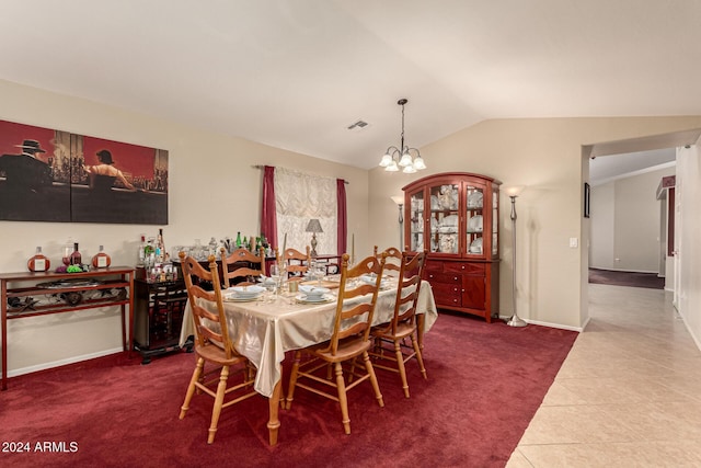 dining area featuring a chandelier, tile patterned floors, and vaulted ceiling