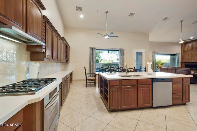 kitchen with plenty of natural light, appliances with stainless steel finishes, ceiling fan, tasteful backsplash, and sink