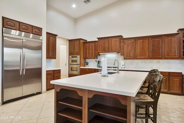 kitchen featuring tasteful backsplash, appliances with stainless steel finishes, a breakfast bar, and high vaulted ceiling