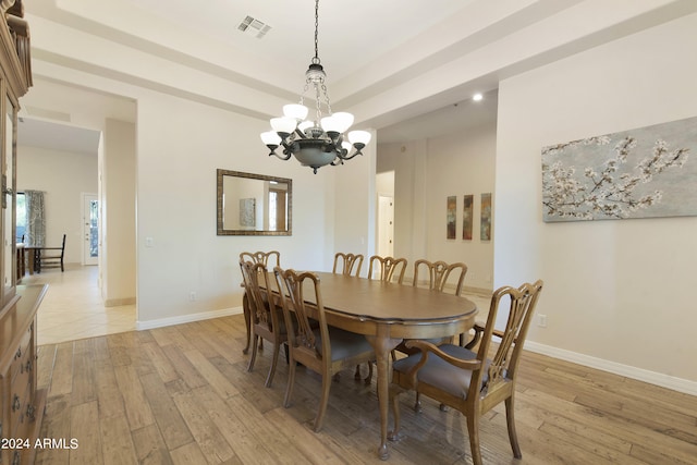 dining room with light hardwood / wood-style floors and a notable chandelier