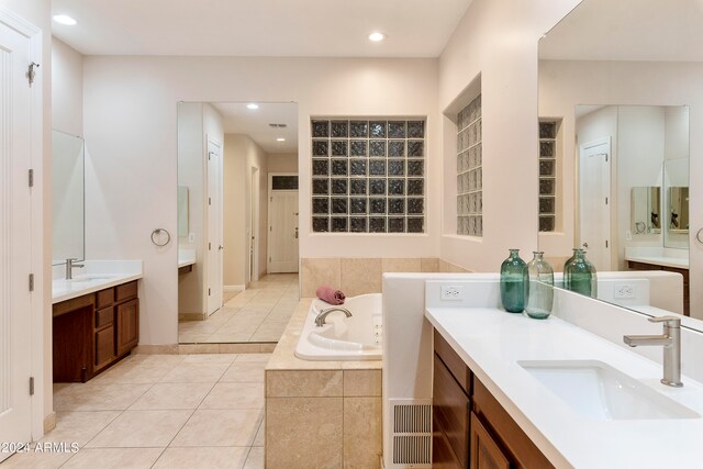 bathroom with vanity, tile floors, and tiled tub