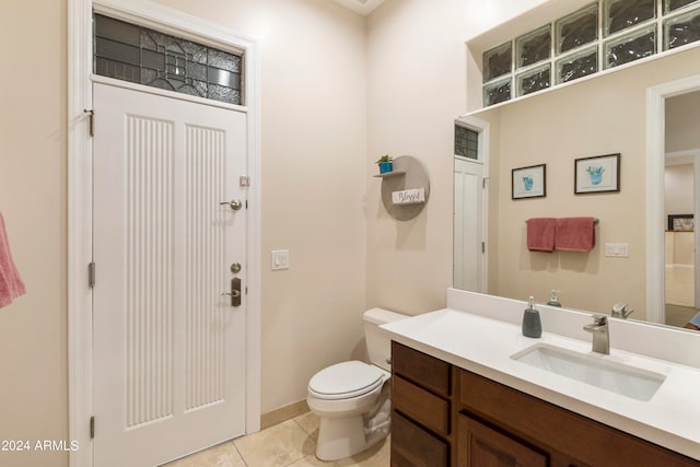 bathroom with toilet, tile floors, and vanity