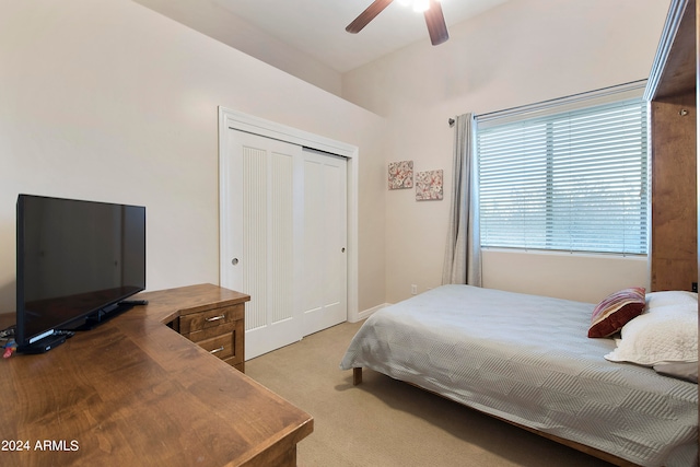 bedroom featuring light carpet, a closet, ceiling fan, and vaulted ceiling