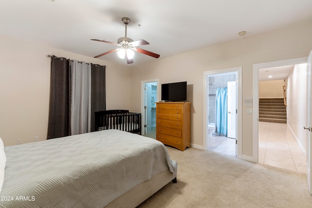 carpeted bedroom featuring a spacious closet, ceiling fan, and ensuite bathroom