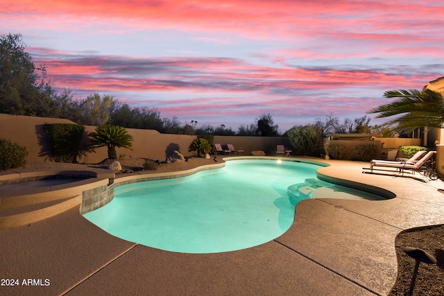 pool at dusk with a patio