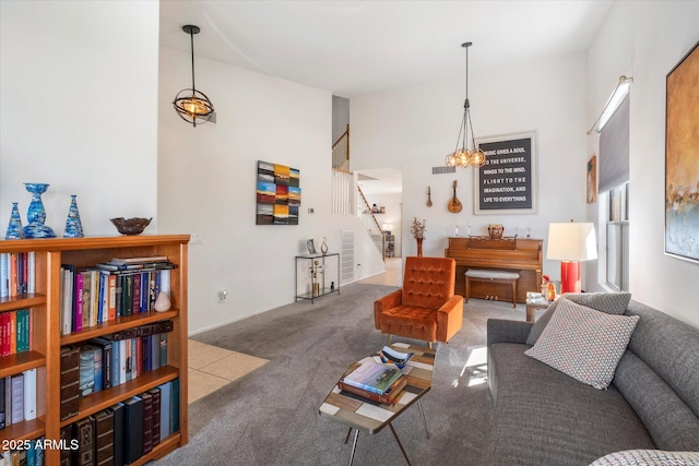 living area featuring stairway, visible vents, a high ceiling, and carpet floors