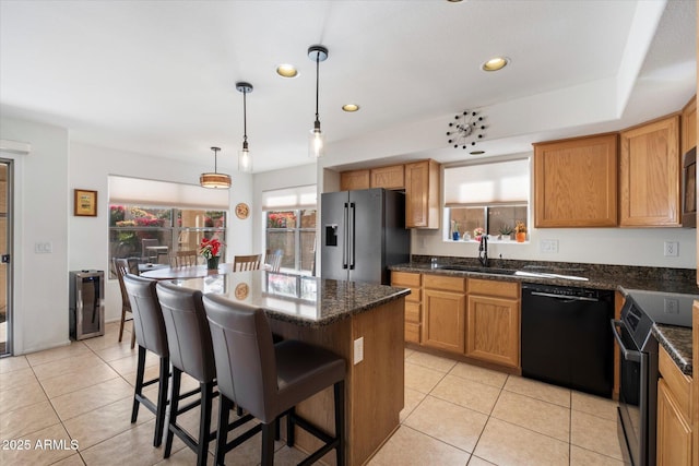 kitchen with a sink, light tile patterned flooring, a kitchen island, and stainless steel appliances