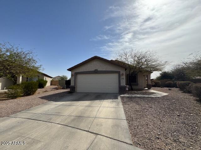 single story home featuring a garage, driveway, and stucco siding