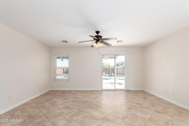 unfurnished room featuring a wealth of natural light, visible vents, and ceiling fan