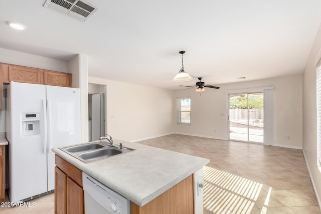 kitchen featuring visible vents, a sink, white appliances, light countertops, and ceiling fan