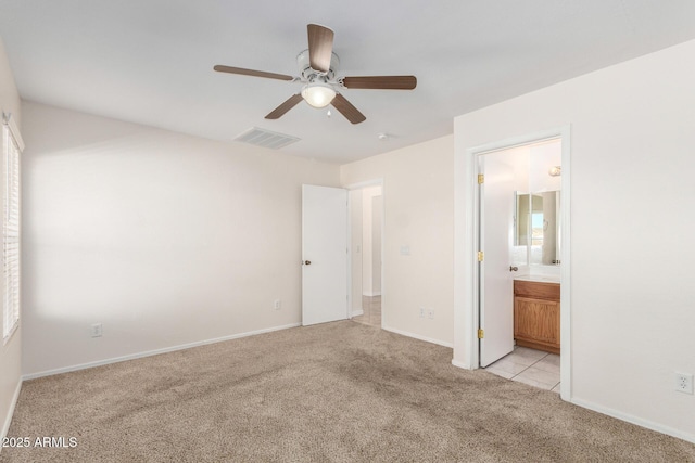 unfurnished bedroom with visible vents, a ceiling fan, connected bathroom, baseboards, and light colored carpet