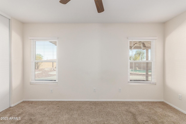 spare room with baseboards, light carpet, plenty of natural light, and ceiling fan