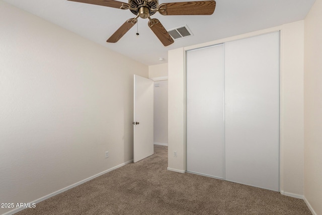unfurnished bedroom with visible vents, baseboards, carpet, a closet, and a ceiling fan