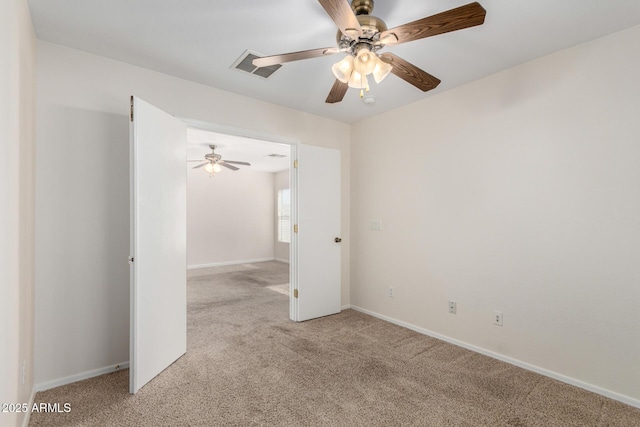 unfurnished room with a ceiling fan, light colored carpet, and baseboards