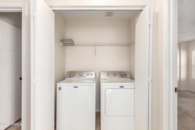 laundry area featuring washing machine and clothes dryer, laundry area, visible vents, and carpet floors