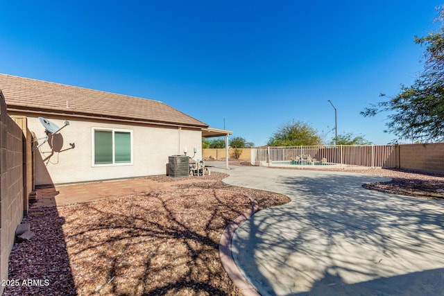 view of yard featuring a fenced in pool, central AC, a fenced backyard, and a patio area