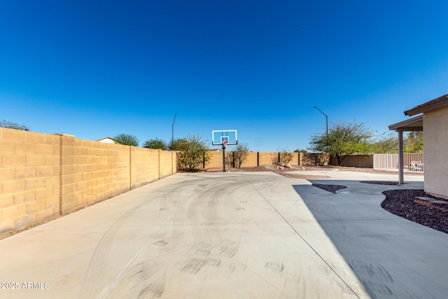 view of patio / terrace with basketball hoop and a fenced backyard