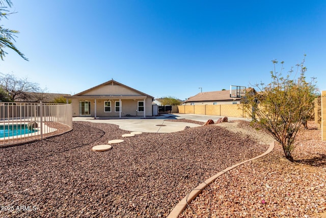 back of property featuring a patio area, a fenced in pool, and a fenced backyard