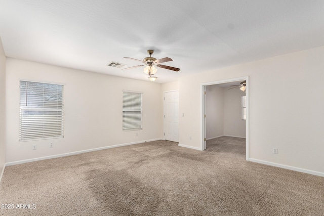 unfurnished room featuring visible vents, baseboards, ceiling fan, and carpet flooring