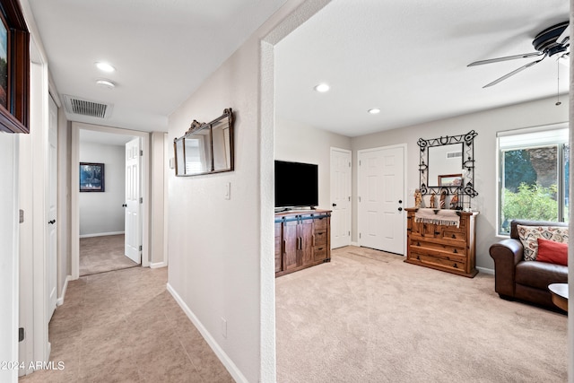 interior space with light carpet and ceiling fan