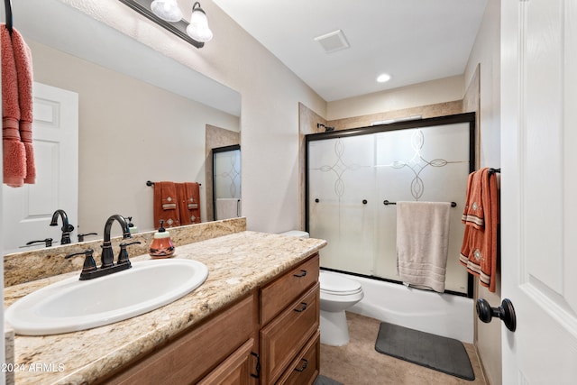 full bathroom with toilet, vanity, tile patterned floors, and shower / bath combination with glass door