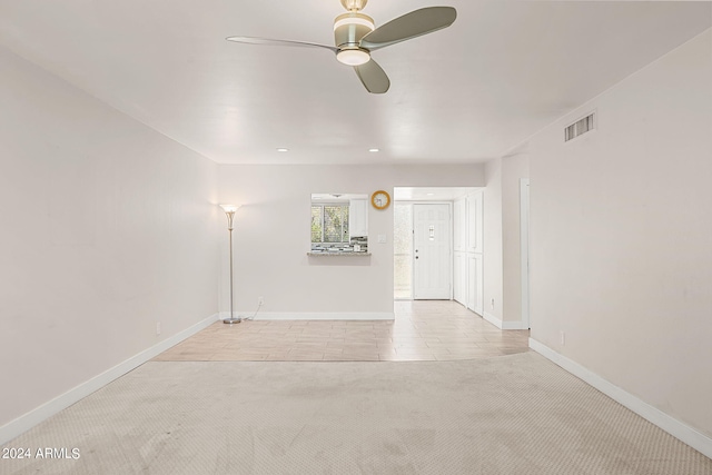 empty room featuring ceiling fan and light colored carpet