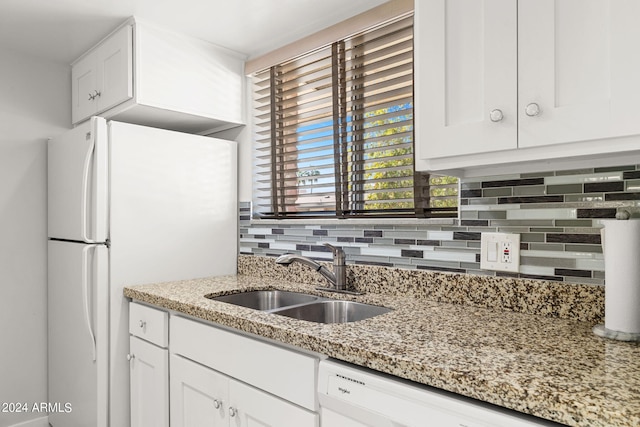 kitchen featuring white cabinets, light stone countertops, white appliances, and sink