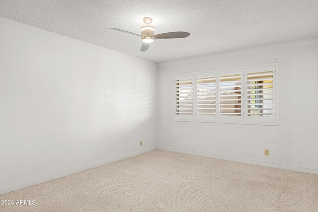 empty room with light colored carpet, ceiling fan, and a textured ceiling