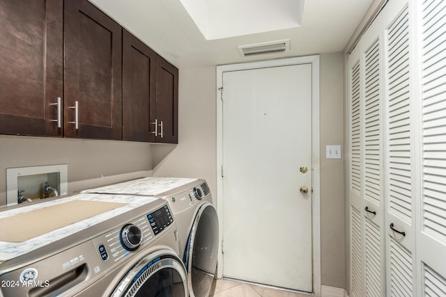 laundry area with separate washer and dryer, light tile patterned floors, and cabinets