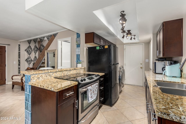 kitchen with stainless steel range with electric stovetop, sink, light tile patterned flooring, light stone counters, and washer / dryer