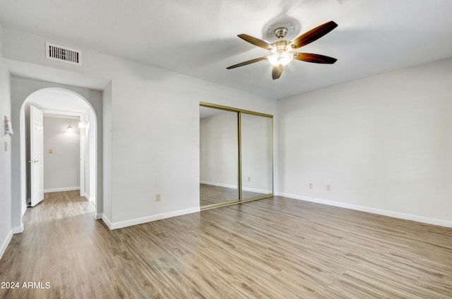 unfurnished bedroom featuring ceiling fan, a closet, and light hardwood / wood-style floors