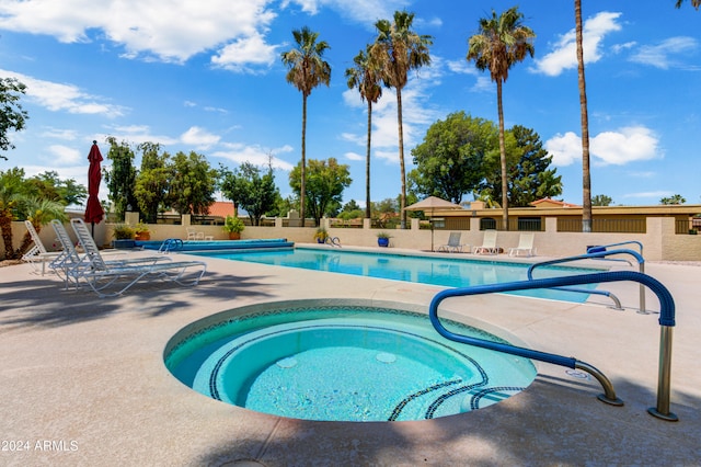 view of pool with a patio and a hot tub