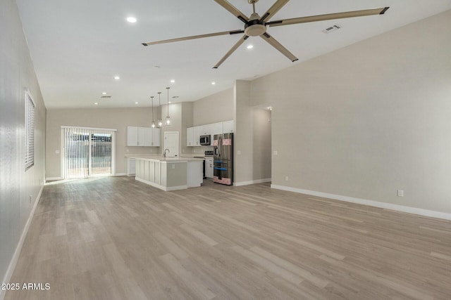 unfurnished living room featuring ceiling fan, light wood-type flooring, sink, and high vaulted ceiling