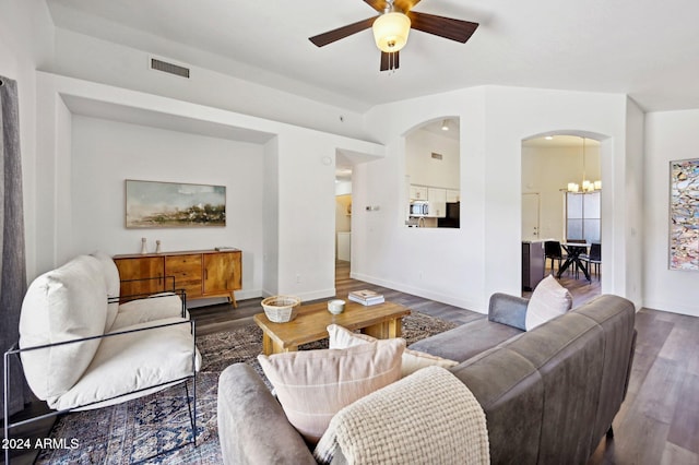 living room with dark wood-type flooring and ceiling fan with notable chandelier